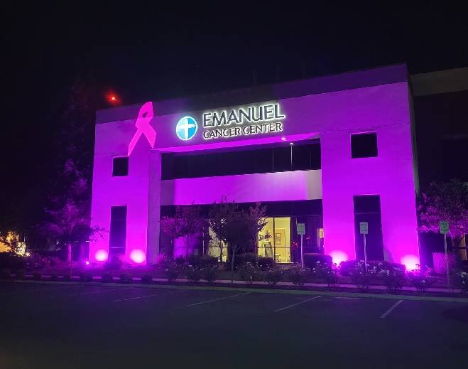 Cancer center building lit pink at night
