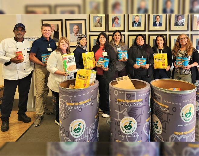 Staff holding donated food items