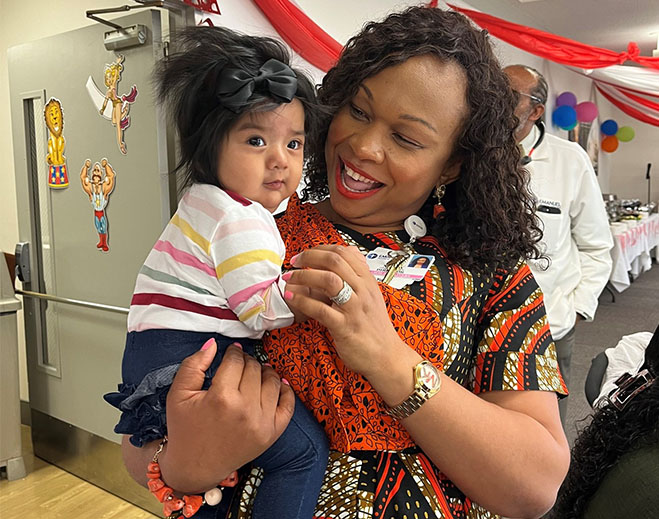 Adult holding baby at community event