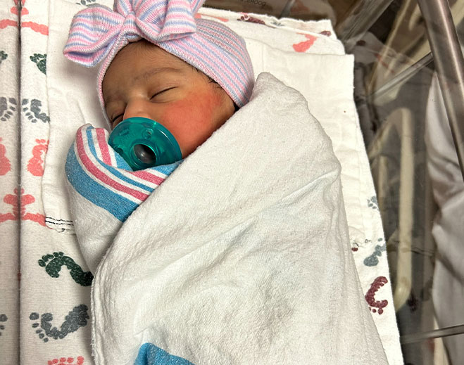 Newborn infant swaddled in hospital blanket