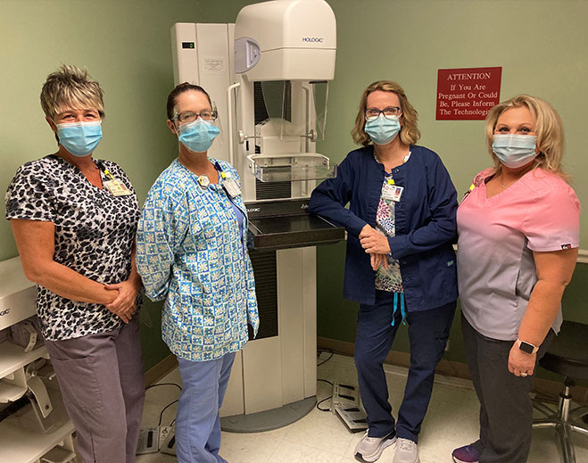 Mammography team beside breast imaging equipment