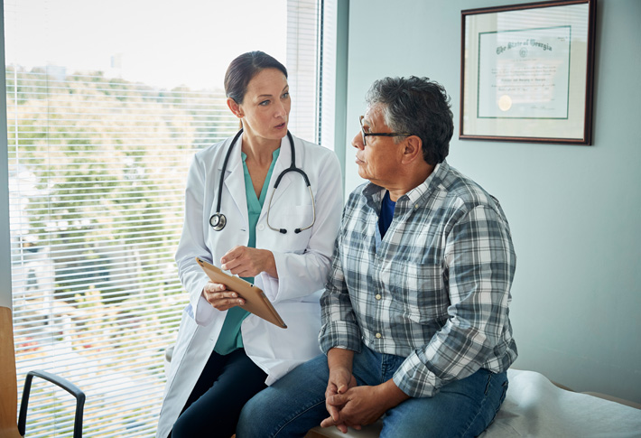 Doctor using fetal Doppler on pregnant abdomen